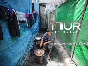 A displaced Palestinian man, who has fled his home due to Israeli strikes, is looking on as he shelters in a UNRWA-affiliated school amid th...