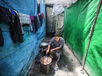 A displaced Palestinian man, who has fled his home due to Israeli strikes, is looking on as he shelters in a UNRWA-affiliated school amid th...