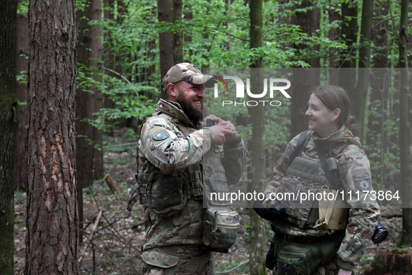 Military personnel from the Liut (Fury) Brigade of the National Police of Ukraine are sharing a laugh before starting drills at a training a...