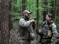 Military personnel from the Liut (Fury) Brigade of the National Police of Ukraine are sharing a laugh before starting drills at a training a...