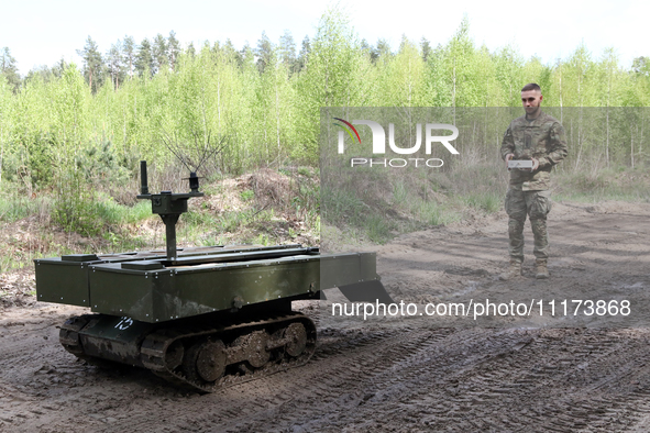 A serviceman is standing before the VEPR ground logistics robotic complex during drills of the Liut (Fury) Brigade of the National Police of...