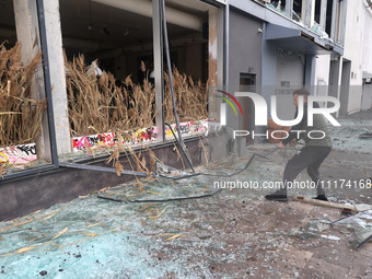 A man is removing broken glass in the Shevchenkivskyi district after a Russian missile attack in Kharkiv, Ukraine, on April 24, 2024. (