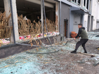 A man is removing broken glass in the Shevchenkivskyi district after a Russian missile attack in Kharkiv, Ukraine, on April 24, 2024. (