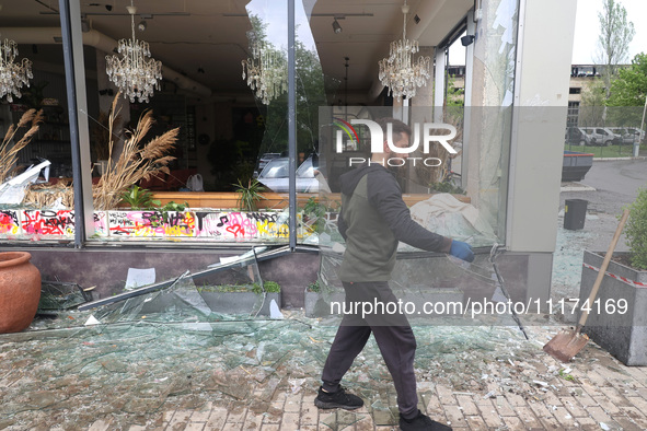 A man is removing broken glass in the Shevchenkivskyi district after a Russian missile attack in Kharkiv, Ukraine, on April 24, 2024. 