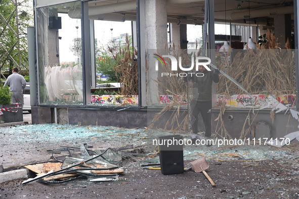 A man is removing broken glass in the Shevchenkivskyi district after a Russian missile attack in Kharkiv, northeastern Ukraine, on April 24,...