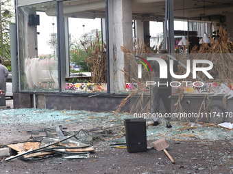 A man is removing broken glass in the Shevchenkivskyi district after a Russian missile attack in Kharkiv, northeastern Ukraine, on April 24,...