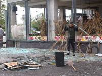 A man is removing broken glass in the Shevchenkivskyi district after a Russian missile attack in Kharkiv, northeastern Ukraine, on April 24,...