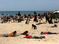 Palestinians are enjoying the beach on a hot day, amid the ongoing conflict between Israel and Hamas, in Deir Al-Balah, in the central Gaza...