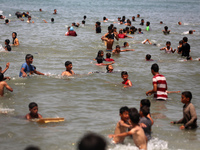 Palestinians are enjoying the beach on a hot day, amid the ongoing conflict between Israel and Hamas, in Deir Al-Balah, in the central Gaza...