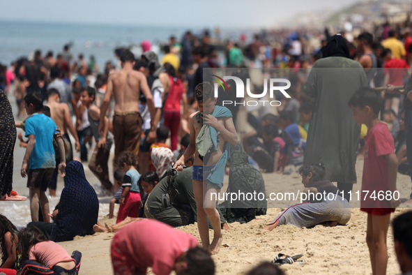 Palestinians are enjoying the beach on a hot day, amid the ongoing conflict between Israel and Hamas, in Deir Al-Balah, in the central Gaza...