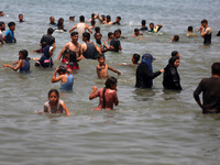 Palestinians are enjoying the beach on a hot day, amid the ongoing conflict between Israel and Hamas, in Deir Al-Balah, in the central Gaza...