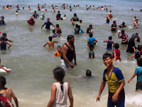 Palestinians are enjoying the beach on a hot day, amid the ongoing conflict between Israel and Hamas, in Deir Al-Balah, in the central Gaza...