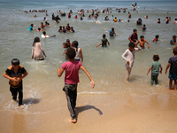 Palestinians are enjoying the beach on a hot day, amid the ongoing conflict between Israel and Hamas, in Deir Al-Balah, in the central Gaza...