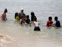 Palestinians are enjoying the beach on a hot day, amid the ongoing conflict between Israel and Hamas, in Deir Al-Balah, in the central Gaza...