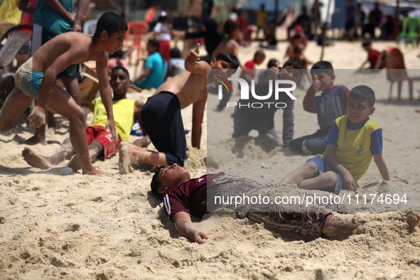 Palestinians are enjoying the beach on a hot day, amid the ongoing conflict between Israel and Hamas, in Deir Al-Balah, in the central Gaza...