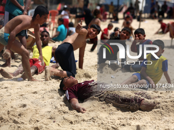 Palestinians are enjoying the beach on a hot day, amid the ongoing conflict between Israel and Hamas, in Deir Al-Balah, in the central Gaza...