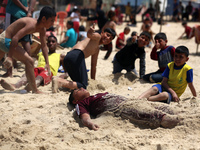 Palestinians are enjoying the beach on a hot day, amid the ongoing conflict between Israel and Hamas, in Deir Al-Balah, in the central Gaza...