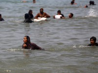 Palestinians are enjoying the beach on a hot day, amid the ongoing conflict between Israel and Hamas, in Deir Al-Balah, in the central Gaza...