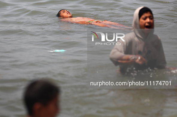 Palestinians are enjoying the beach on a hot day, amid the ongoing conflict between Israel and Hamas, in Deir Al-Balah, in the central Gaza...