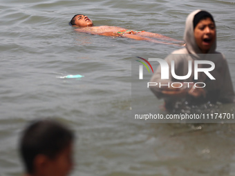 Palestinians are enjoying the beach on a hot day, amid the ongoing conflict between Israel and Hamas, in Deir Al-Balah, in the central Gaza...