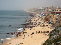 Palestinians are enjoying the beach on a hot day, amid the ongoing conflict between Israel and Hamas, in Deir Al-Balah, in the central Gaza...