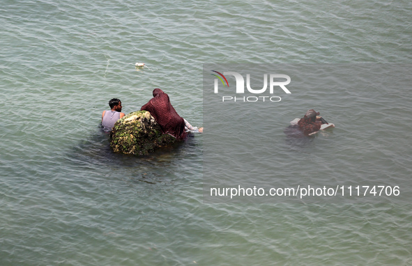 Palestinians are enjoying the beach on a hot day, amid the ongoing conflict between Israel and Hamas, in Deir Al-Balah, in the central Gaza...