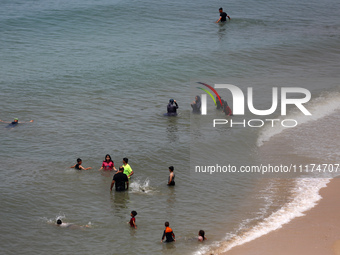 Palestinians are enjoying the beach on a hot day, amid the ongoing conflict between Israel and Hamas, in Deir Al-Balah, in the central Gaza...