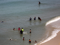 Palestinians are enjoying the beach on a hot day, amid the ongoing conflict between Israel and Hamas, in Deir Al-Balah, in the central Gaza...