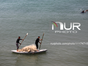 Palestinian fishermen are working in the sea amid the ongoing conflict between Israel and Hamas in Deir Al-Balah, in the central Gaza Strip,...