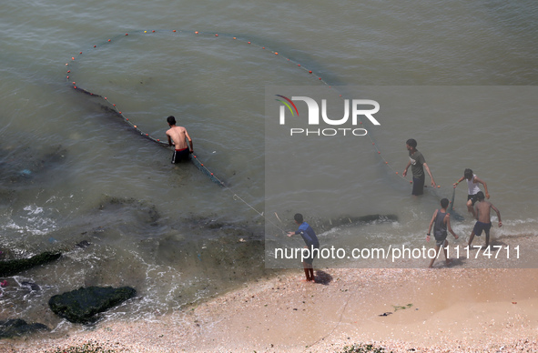 Palestinian fishermen are working in the sea amid the ongoing conflict between Israel and Hamas in Deir Al-Balah, in the central Gaza Strip,...