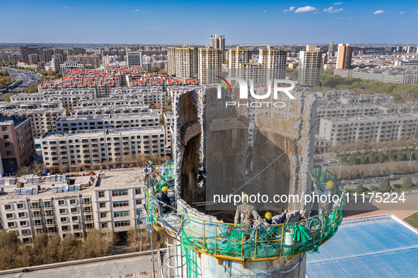 An aerial photo is showing the demolition of a chimney at the Thermal Company in Jiuquan, Gansu Province, China, on April 20, 2024. 