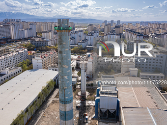 An aerial photo is showing the demolition of a chimney at the Thermal Company in Jiuquan, Gansu Province, China, on April 20, 2024. (