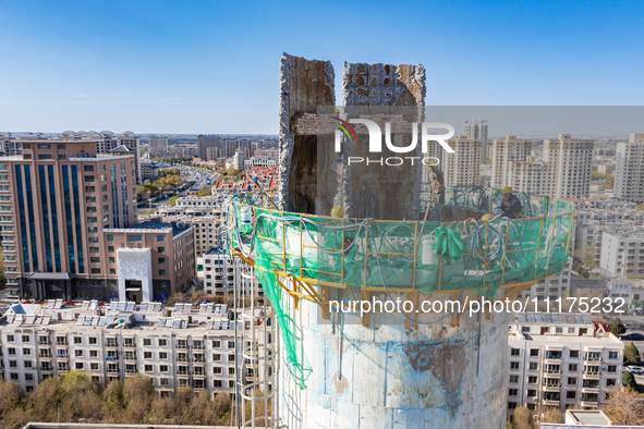 An aerial photo is showing the demolition of a chimney at the Thermal Company in Jiuquan, Gansu Province, China, on April 20, 2024. 