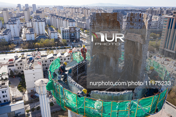 An aerial photo is showing the demolition of a chimney at the Thermal Company in Jiuquan, Gansu Province, China, on April 20, 2024. 