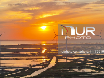 A wind farm is being seen at sunset in Wuxi, China, on April 24, 2024. (