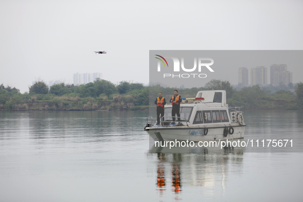 Fishing officials are driving a boat and using a drone to conduct a no-fishing inspection in the Shunqing section of the Jialing River in Na...