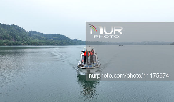 Fishing officials are driving a boat and using a drone to conduct a no-fishing inspection in the Shunqing section of the Jialing River in Na...