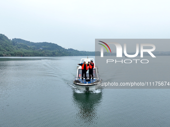 Fishing officials are driving a boat and using a drone to conduct a no-fishing inspection in the Shunqing section of the Jialing River in Na...