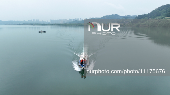 Fishing officials are driving a boat and using a drone to conduct a no-fishing inspection in the Shunqing section of the Jialing River in Na...