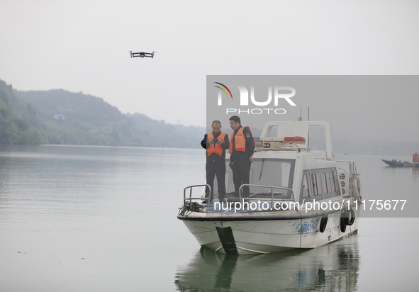 Fishing officials are driving a boat and using a drone to conduct a no-fishing inspection in the Shunqing section of the Jialing River in Na...