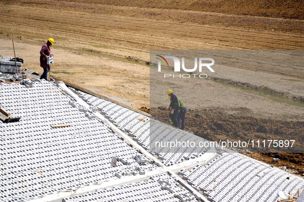 Workers are reinforcing beaches and embankments in Suqian, Jiangsu Province, China, on April 25, 2024. 