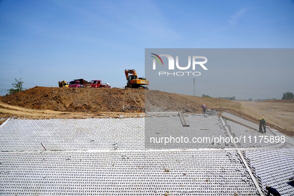 Workers are reinforcing beaches and embankments in Suqian, Jiangsu Province, China, on April 25, 2024. 