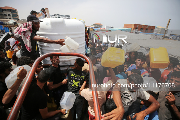 Displaced Palestinians are lining up to fill their containers with water in Deir Balah in the central Gaza Strip on April 25, 2024, amid ong...