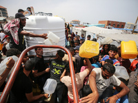 Displaced Palestinians are lining up to fill their containers with water in Deir Balah in the central Gaza Strip on April 25, 2024, amid ong...