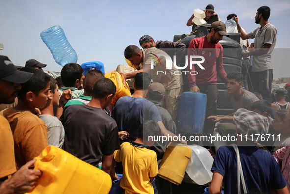 Displaced Palestinians are lining up to fill their containers with water in Deir Balah in the central Gaza Strip on April 25, 2024, amid ong...