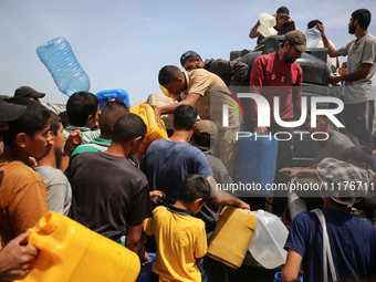 Displaced Palestinians are lining up to fill their containers with water in Deir Balah in the central Gaza Strip on April 25, 2024, amid ong...