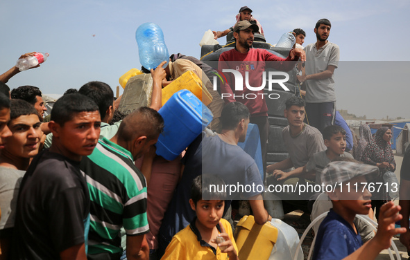 Displaced Palestinians are lining up to fill their containers with water in Deir Balah in the central Gaza Strip on April 25, 2024, amid ong...