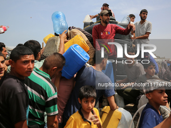 Displaced Palestinians are lining up to fill their containers with water in Deir Balah in the central Gaza Strip on April 25, 2024, amid ong...