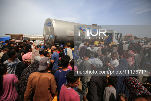 Displaced Palestinians are lining up to fill their containers with water in Deir Balah in the central Gaza Strip on April 25, 2024, amid ong...