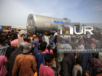 Displaced Palestinians are lining up to fill their containers with water in Deir Balah in the central Gaza Strip on April 25, 2024, amid ong...